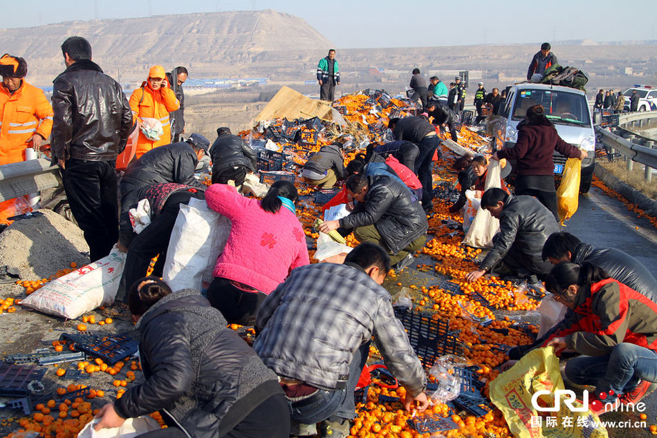 兰州货车侧翻橘子遭哄抢 民警持枪维持秩序