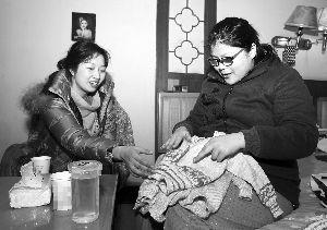 工作人员为乐燕(右)即将出生的孩子准备了小毛衣