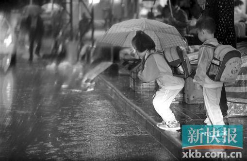 前天广州暴雨,广州多数学校并未停课。图为西华路上幼儿园的孩子跳过积水。陈秋明/摄 前天广州暴雨,广州多数学校并未停课。图为西华路上幼儿园的孩子跳过积水。陈秋明/摄
